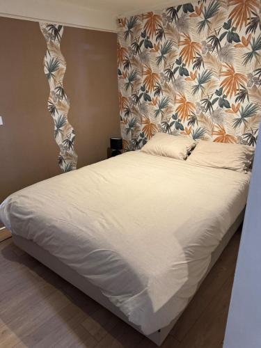 a bed in a bedroom with a floral headboard at Studio au rdc cœur de ville 1 in Sélestat