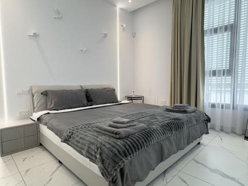 a bedroom with a large bed with towels on it at SWIFT Suites Limassol in Limassol