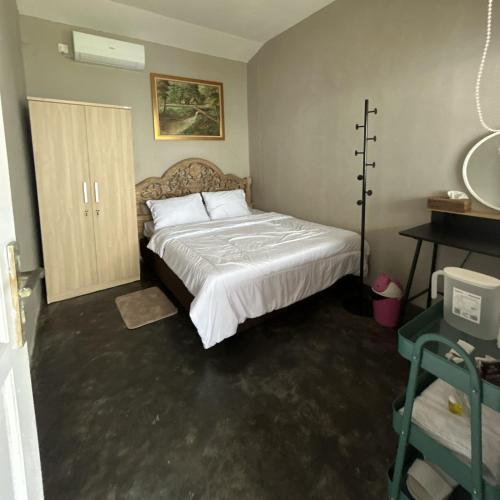 a bedroom with a large bed and a mirror at Homestay IDR Bali in Jimbaran