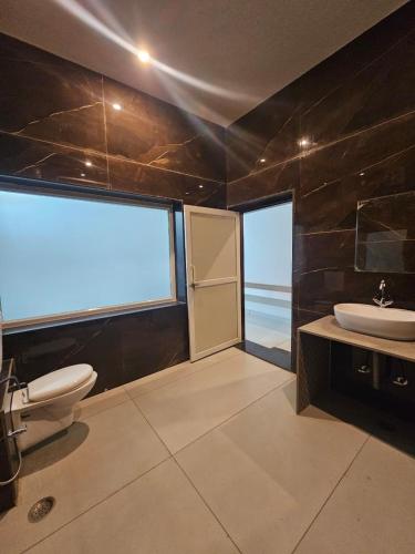 a bathroom with a sink and a toilet and a window at Brahma Heritage Resort in Pushkar