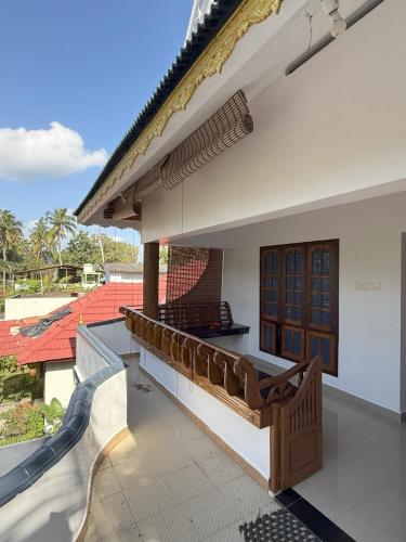a balcony of a house with a bench on it at Soul Shore, Varkala in Varkala