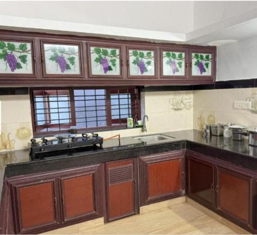 a large kitchen with wooden cabinets and windows at Soul Shore, Varkala in Varkala