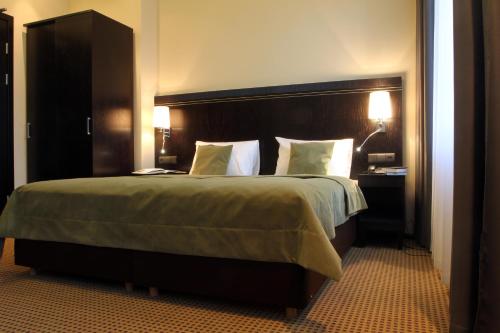 a bedroom with a large bed with a wooden headboard at Hotel Fado Spa & Restaurant in Świdnica
