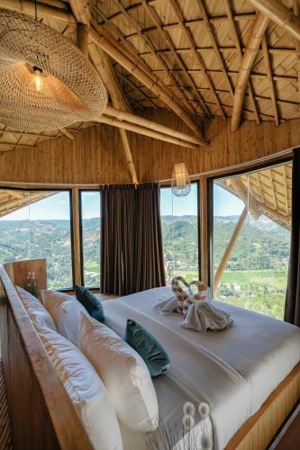 a large bed in a room with large windows at Buenavista Lux Villas in Kuta Lombok