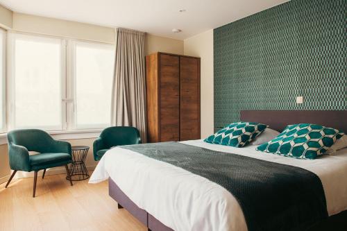 a bedroom with a large bed and two chairs at B&B Maaltebrug in Ghent