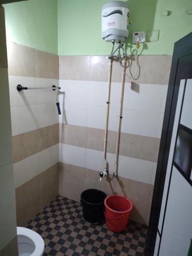 a bathroom with a toilet and buckets in a room at Bridgettine Paradise 2 in Kalpetta