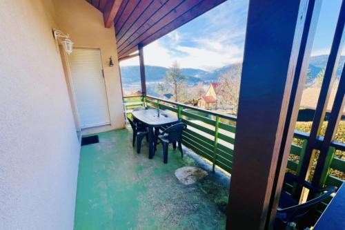 a balcony with a table and chairs and a view at Cozy apartment with lake view in Gérardmer