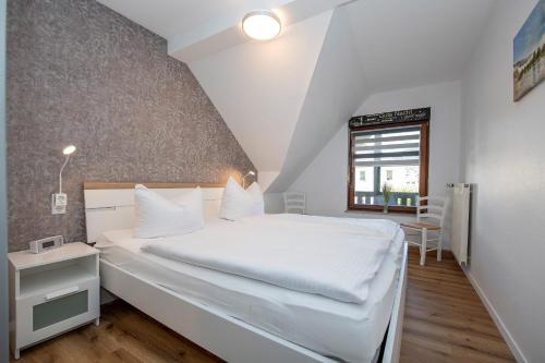 a bedroom with a white bed and a window at Ferienwohnungen by Weingut Hommes in Ernst Mosel in Ernst