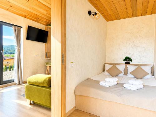 a bedroom with a bed with towels on it at Royal Hill-Queen Chalet -Bran, Mountain View and Hot Tub in Sohodol
