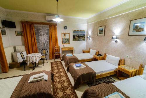 una camera d'albergo con due letti e un tavolo di Zozas Rooms a Kalabaka
