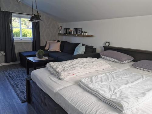 a bedroom with a large bed and a couch at Cozy Fjord Studio in Åna-Sira Near Brufjell and Jøssingfjord in Flekkefjord
