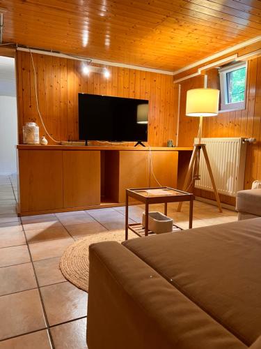 a living room with a tv and a couch and a table at Roche for Toit in Rochefort