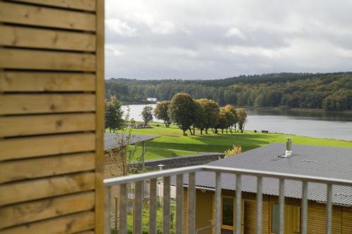a view of a lake from the deck of a house at Madame Vacances Les Cottages De Valjoly in Eppe-Sauvage