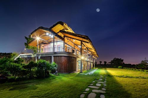 a house on a lawn at night at NSH Riverside Glamping Resort in Hanoi