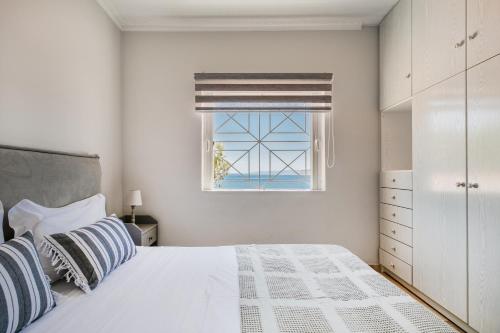 a white bedroom with a bed and a window at Pallas in Keratea