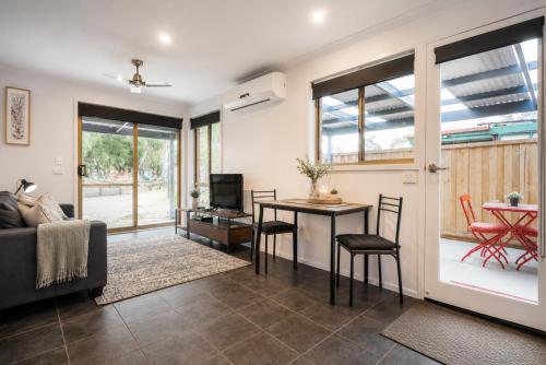 a living room with a couch and a table at Golfside Getaway by Ready Set Stay in Rosebud