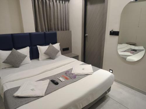 a bedroom with a bed with a blue headboard and a mirror at Hotel Sky Dream in Gandhinagar