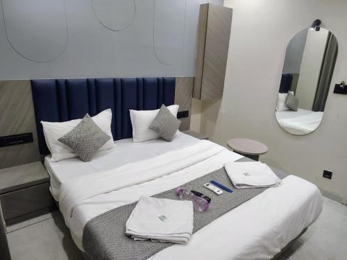 a hotel room with a bed with towels and a mirror at Hotel Sky Dream in Gandhinagar