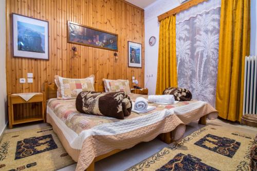 um quarto com 2 camas e cortinas amarelas em Zozas Rooms em Kalabaka