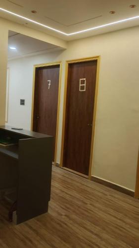 an office with two wooden doors in a room at Kanha Hotel in Kānpur