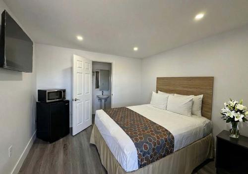 a hotel room with a bed and a television at Sun Valley Motel in Phoenix