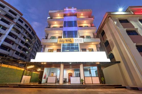 a building with a lit up sign in front of it at Itsy Hotels R S Bhavan, 2 Km From MIT Gate in Manipal