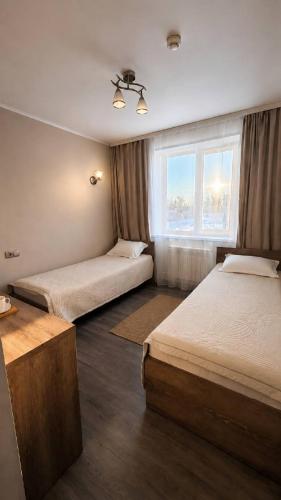 a room with two beds and a window at Baiterek Resort in Karagandy