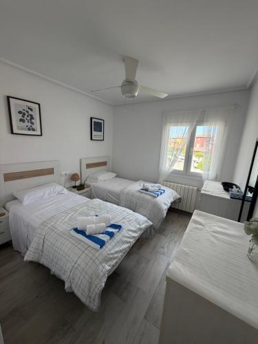 two beds in a white room with windows at Beautiful 3 bed villa on Mar Menor golf resort in Torre-Pacheco