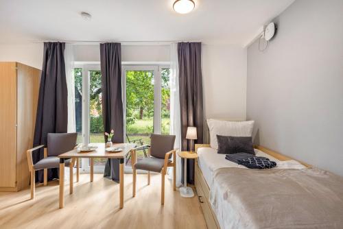 a bedroom with a bed and a table and chairs at Apartments Lübeck in Lübeck