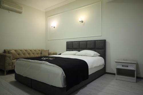a bedroom with a large bed and a couch at Vista Kayseri Hotel in Kayseri