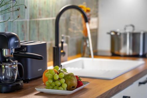 a plate of fruit sitting on a counter next to a sink at Wathay Vendégház in Csesznek