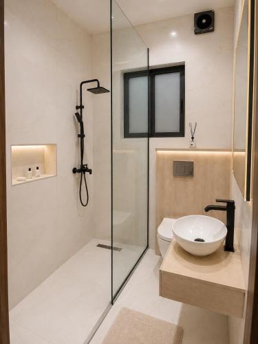a bathroom with a shower and a toilet and a sink at NO 5 Hotel in Lekki