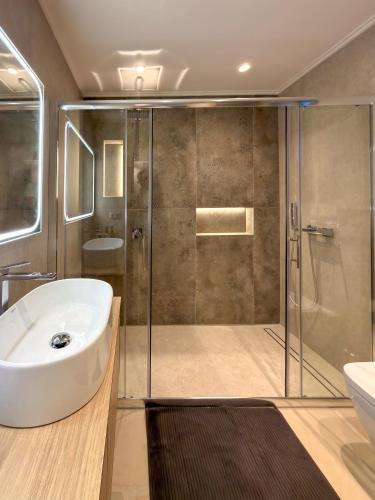 a bathroom with a shower and a sink and a tub at Centaure Inn in Agios Dimitrios