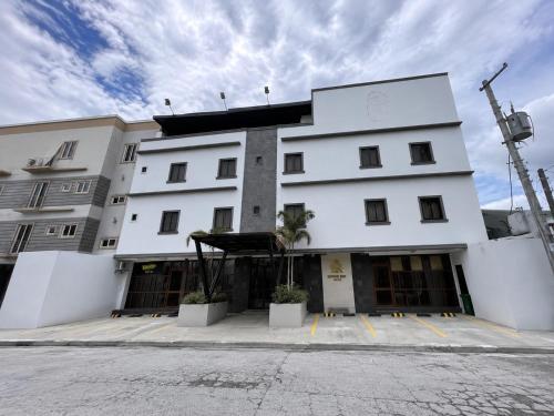 a large white building with a lot of windows at Serene Rise Hotel Angeles City in Angeles