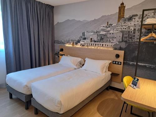 a hotel room with two beds and a wall mural at B&B HOTEL Bastia in Bastia