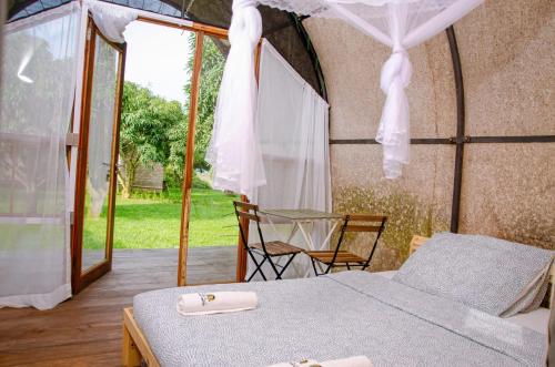 a bedroom in a tent with a bed and a patio at Buvi Camp in Buvi