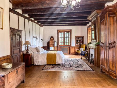 a bedroom with a bed and a desk and a piano at Chateau Eyparsac in Beyssac