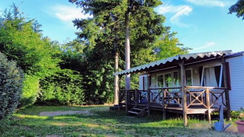 a small cabin in the woods with a porch at Camping les Avenières in Manthes
