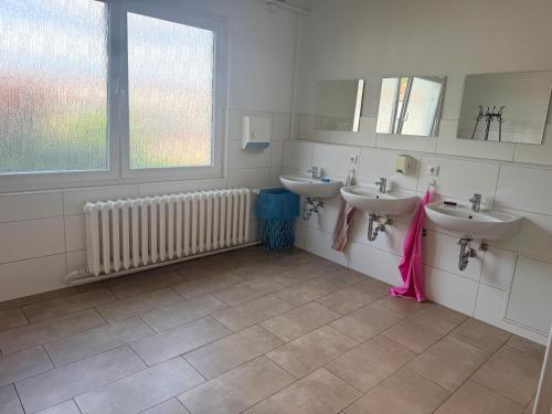 a bathroom with three sinks and a window at Zimmer für Monteure in Crivitz
