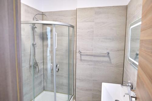 a shower with a glass door in a bathroom at Alezzi Seaside D in Năvodari
