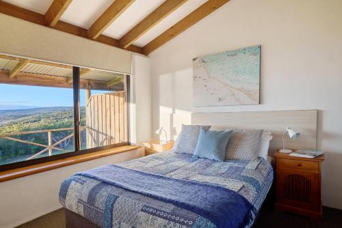 a bedroom with a bed and a large window at Chandlers Smiths Beach Villas in Yallingup