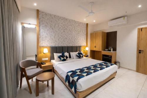 a bedroom with a bed and a desk and a chair at Hotel Premji, Dwarka in Dwarka