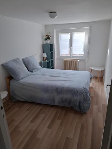 a bedroom with a bed and a wooden floor at Le Puy D'Eraigne in Saint-Nectaire