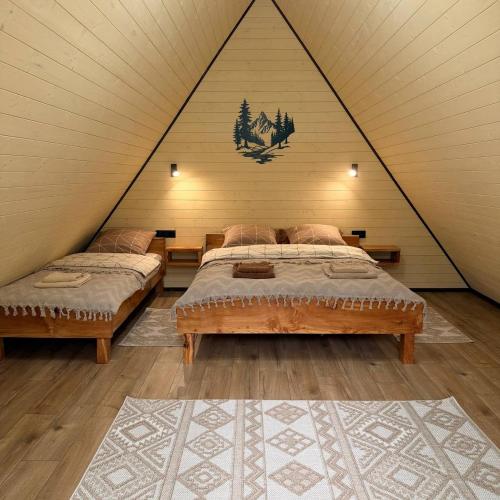 a bedroom with two beds in a triangular room at Подих Свободи in Sloboda