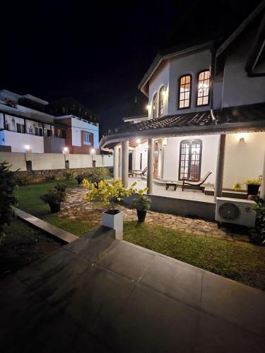 a white house with a bench in front of it at night at Airport Luxury Villa 65 - Negombo-Airport Transit Guest in Negombo