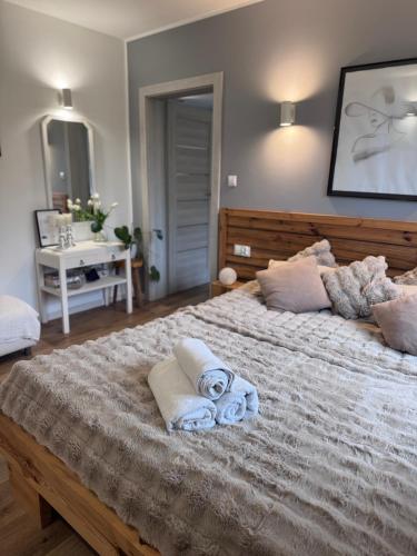 a bedroom with a large bed with towels on it at Domek z jacuzzi Studnica 39 in Studnica