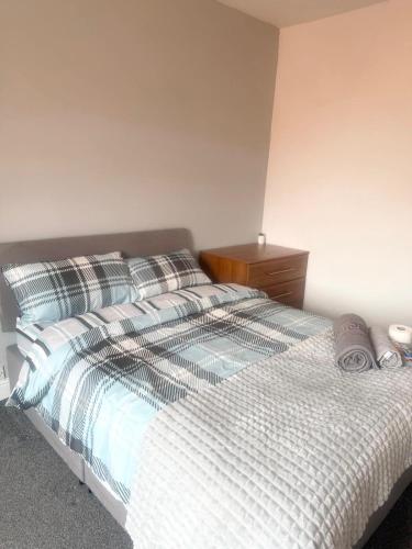 a bedroom with a white bed with a wooden dresser at Relaxing Private Bedroom Stay in Hull