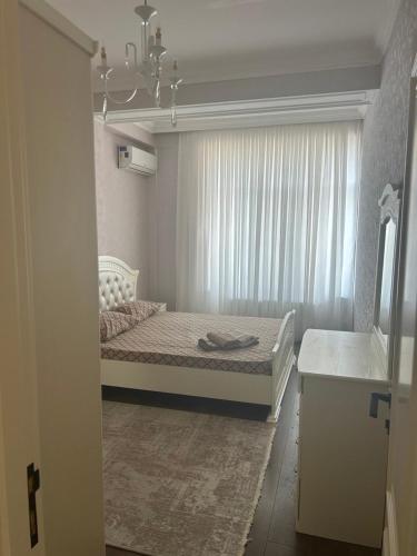 a small bedroom with a bed with a window at Light & Comfortе in Mekhrably