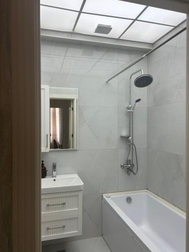 a bathroom with a tub and a sink and a shower at Light & Comfortе in Mekhrably