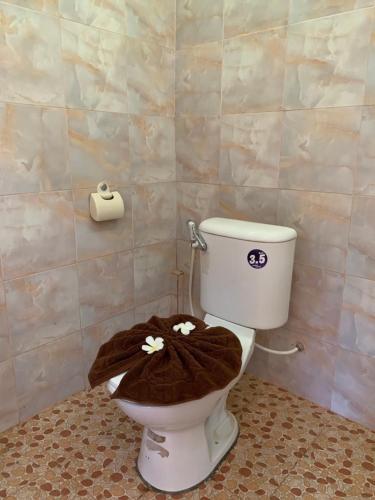 a bathroom with a toilet with a blanket on it at Khaosok Bamboo Huts Resort in Khao Sok National Park